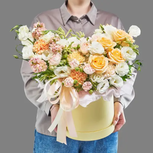 Шляпная коробка с кремовыми розами, белой эустомой и маттиолой