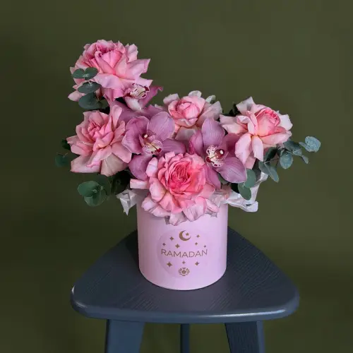 Цветочная композиция из розовых роз и орхидей в шляпной коробке