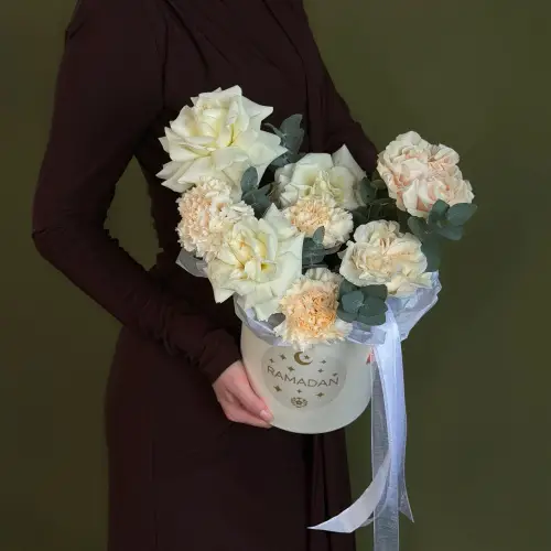 Цветочная композиция из роз и гвоздик с эвкалиптом в шляпной коробке