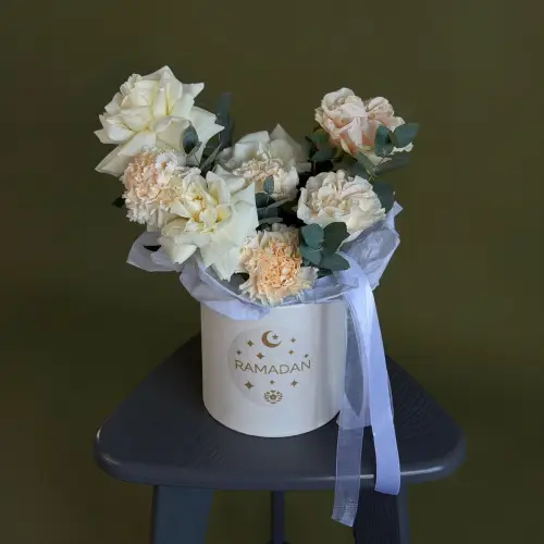 Цветочная композиция из роз и гвоздик с эвкалиптом в шляпной коробке